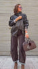 Giacca di pelle nera, camicia leopardata e pantalone marrone